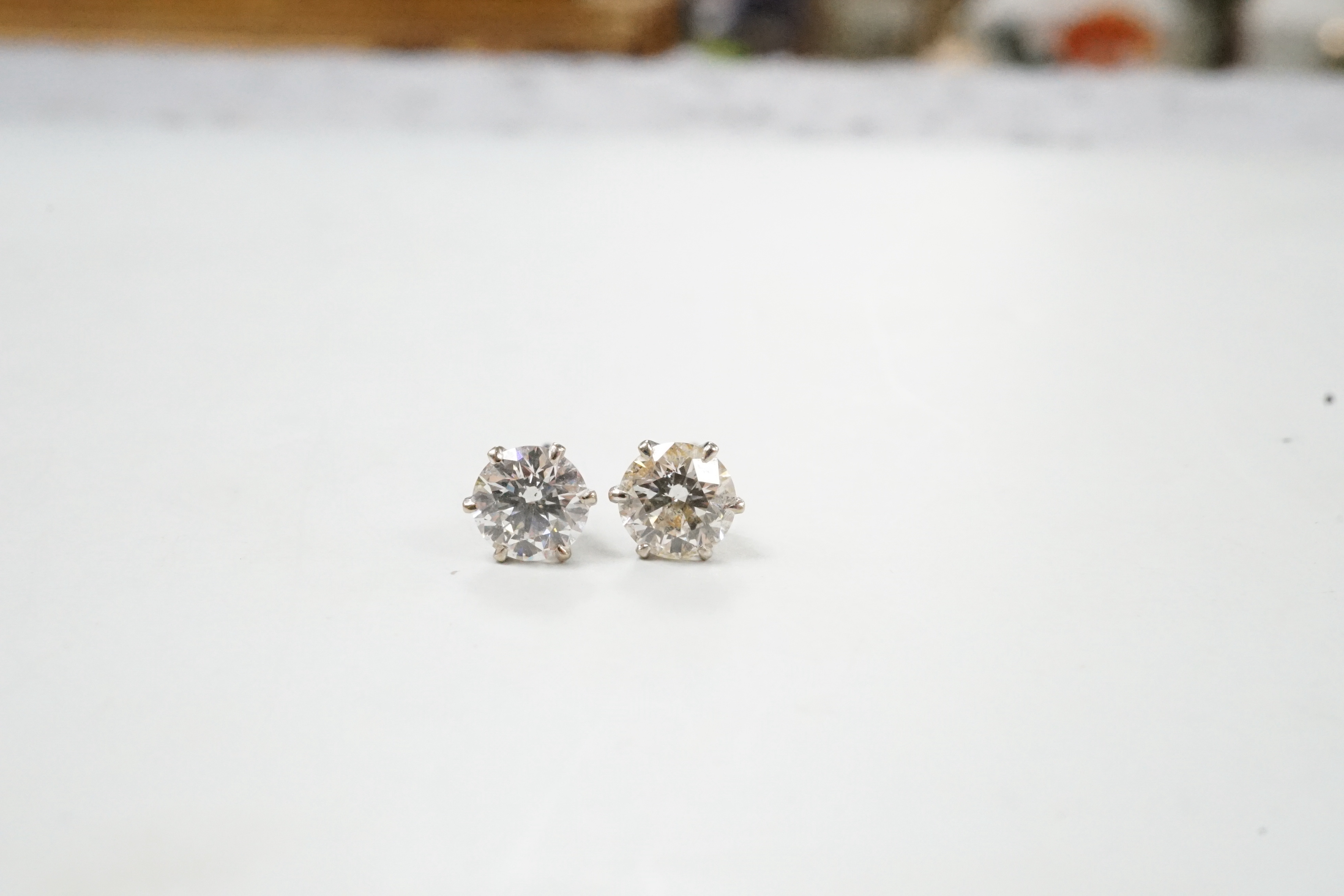 A pair of white metal and solitaire diamond set ear studs